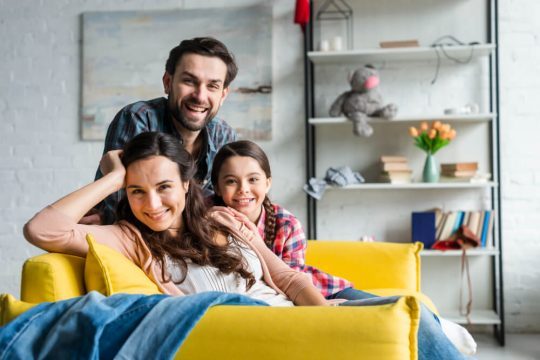 happy-family-sitting-couch-living-room (1)